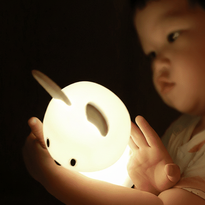 Lámpara nocturna infantil en forma de conejo encendida