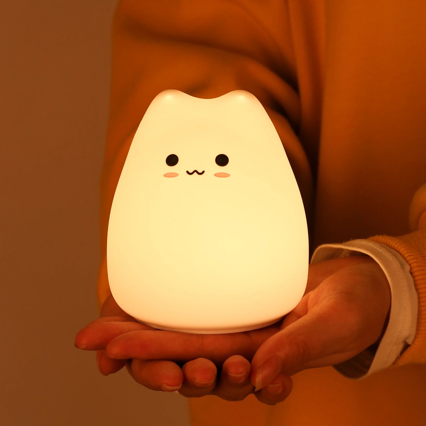 Lámpara infantil con forma de gato encendida, mostrando su luz LED cálida y suave, ideal para crear un ambiente tranquilo en la habitación de los niños.
