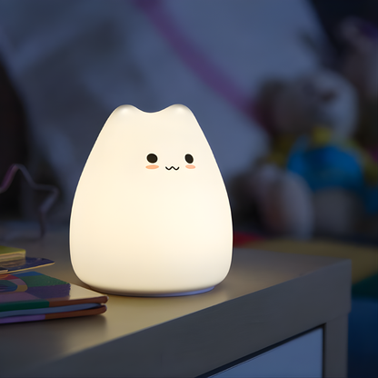 Gato Luminoso fabricado en silicona suave, colocado sobre una mesita de noche infantil, transmitiendo calma y seguridad durante la hora de dormir.